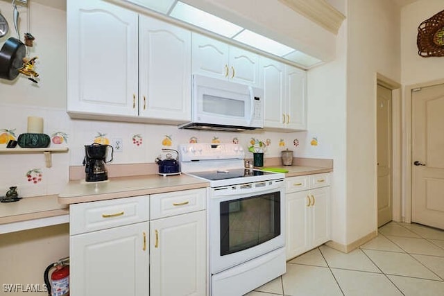 kitchen with light tile patterned floors, white cabinets, and white appliances