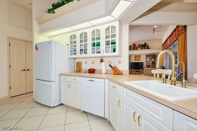 kitchen featuring light tile patterned flooring, sink, white cabinets, and white appliances