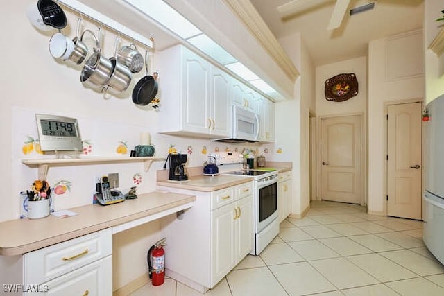 kitchen featuring light tile patterned flooring, white cabinets, and white appliances