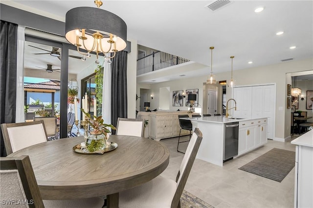 dining space with ceiling fan with notable chandelier and sink