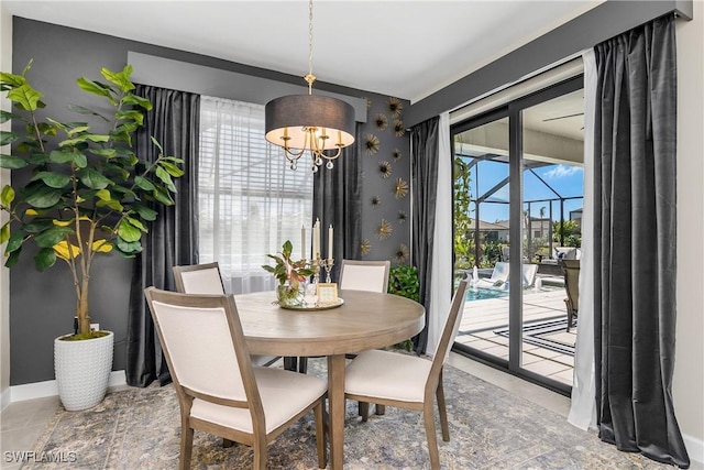 dining room with a wealth of natural light, tile patterned flooring, and a chandelier