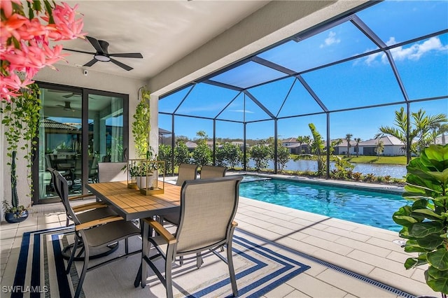 view of pool with ceiling fan, a lanai, a water view, and a patio area