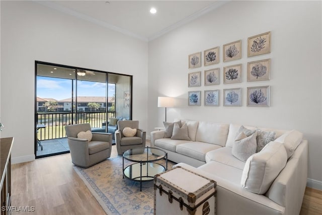 living room featuring hardwood / wood-style flooring, ornamental molding, and a water view