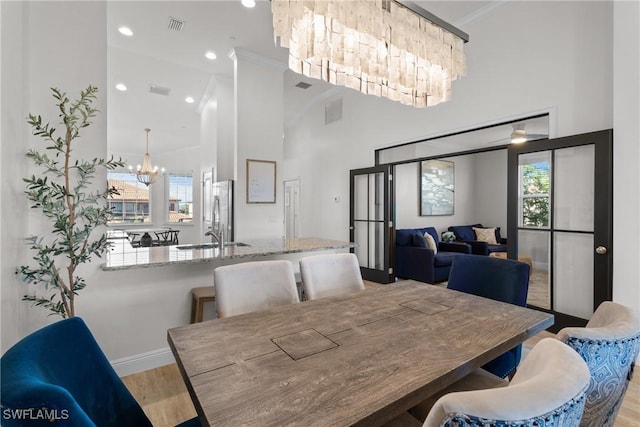 dining space with ornamental molding, light hardwood / wood-style flooring, plenty of natural light, and a notable chandelier