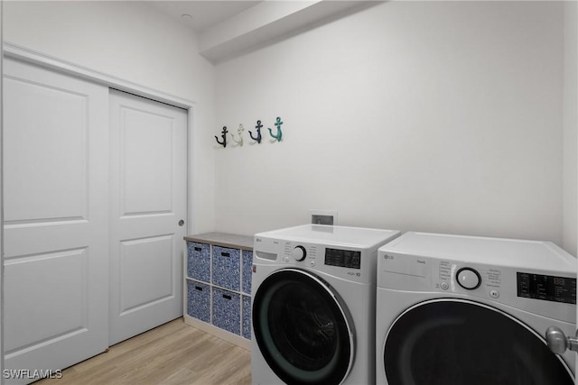 laundry area featuring light wood-type flooring and separate washer and dryer