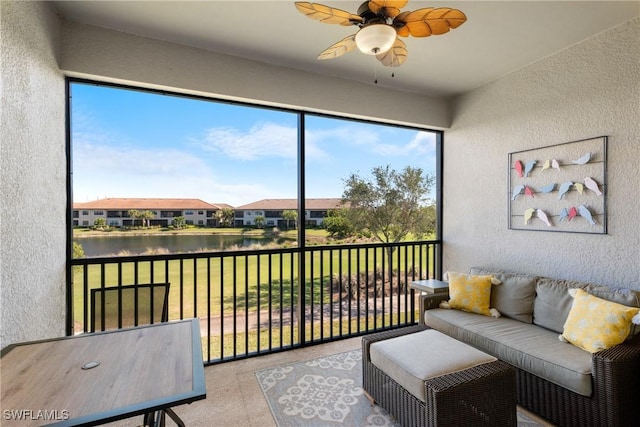 sunroom / solarium featuring a water view and ceiling fan