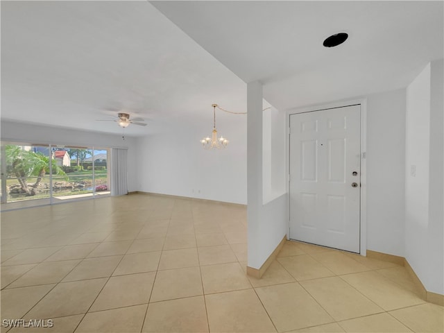 tiled foyer entrance featuring ceiling fan with notable chandelier