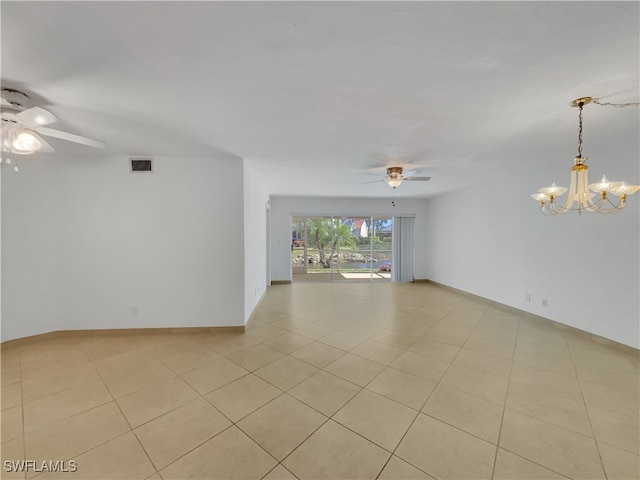 empty room with light tile patterned floors and ceiling fan with notable chandelier