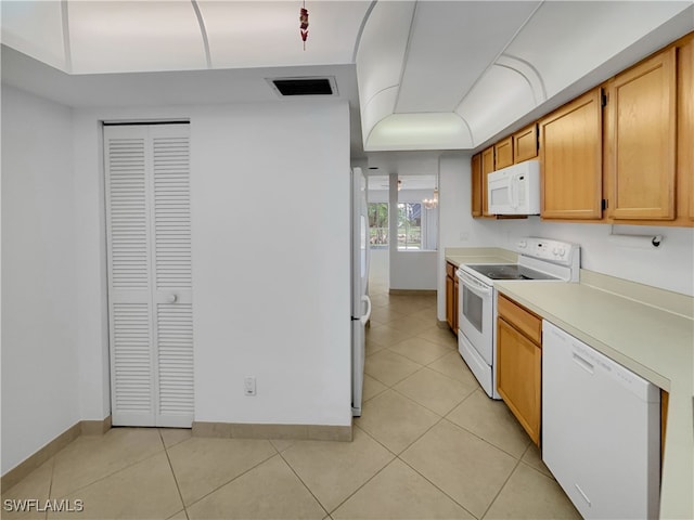 kitchen featuring light tile patterned flooring and white appliances