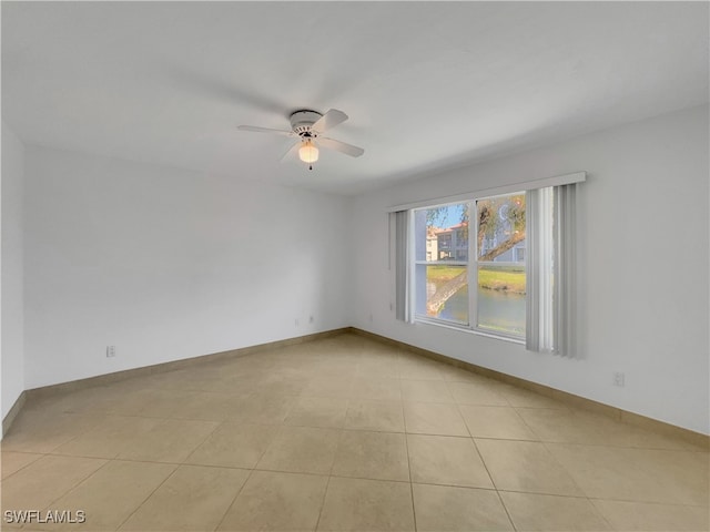 tiled empty room featuring ceiling fan