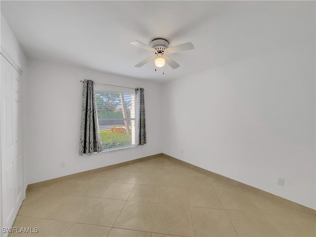 unfurnished room with ceiling fan and light tile patterned flooring