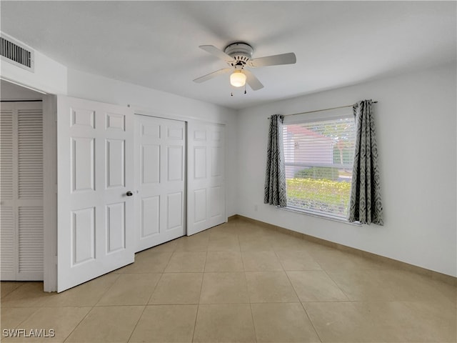 unfurnished bedroom with ceiling fan and light tile patterned flooring