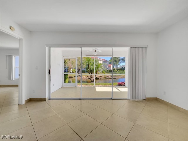 tiled spare room with a wealth of natural light and ceiling fan