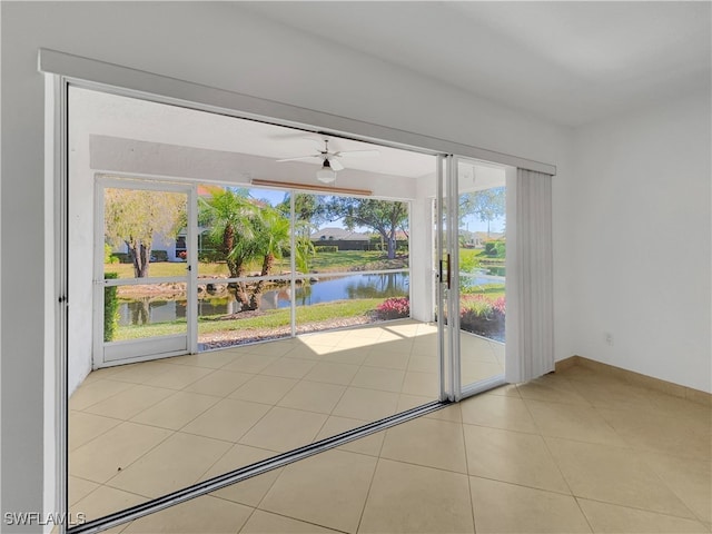 entryway with a water view, ceiling fan, and light tile patterned flooring