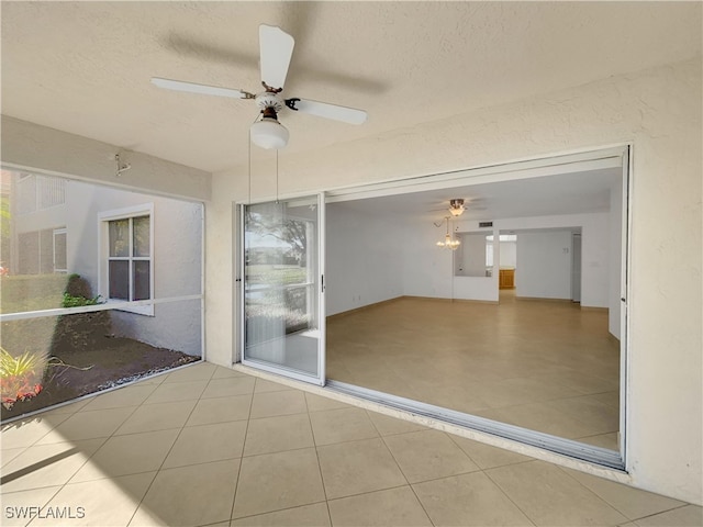 unfurnished sunroom with ceiling fan