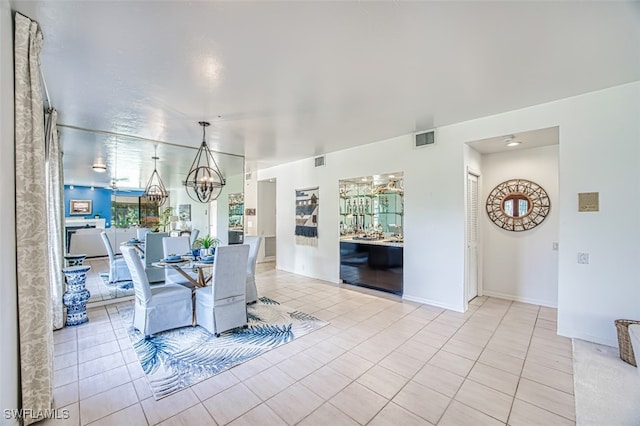 tiled dining room with a notable chandelier