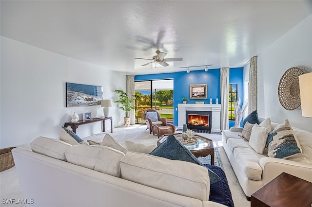 living room featuring carpet floors, track lighting, and ceiling fan