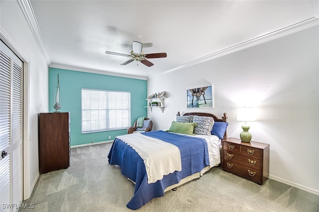 bedroom featuring ornamental molding, light colored carpet, ceiling fan, and a closet