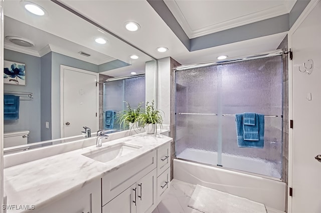 full bathroom featuring ornamental molding, combined bath / shower with glass door, vanity, and toilet