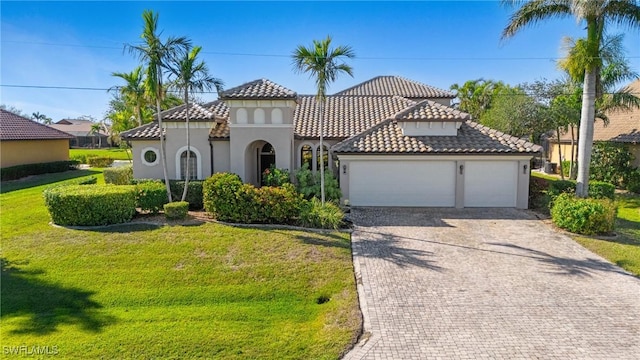 mediterranean / spanish-style house featuring a front yard and a garage