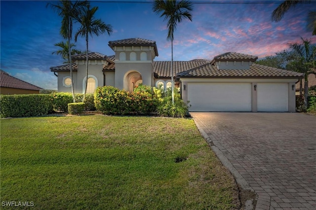 mediterranean / spanish house featuring a yard and a garage