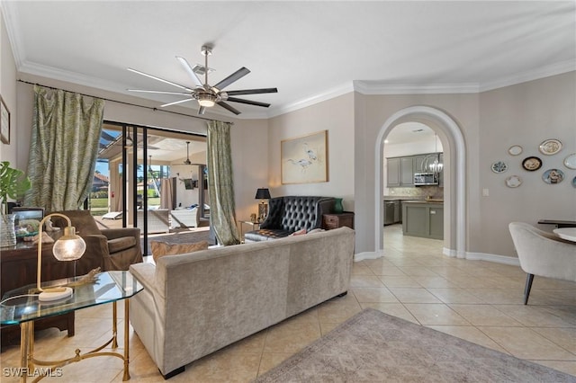 tiled living room with ceiling fan and ornamental molding