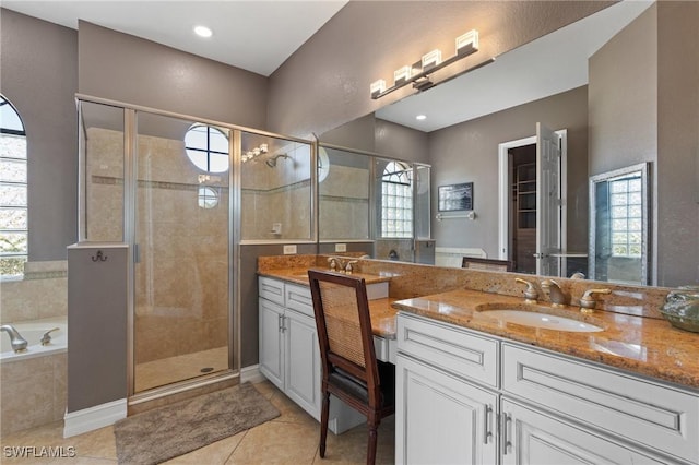 bathroom with vanity, tile patterned flooring, and plus walk in shower