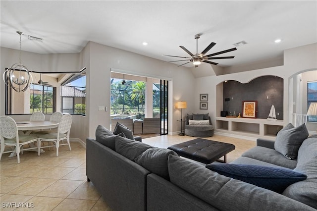 living room with ceiling fan with notable chandelier, light tile patterned floors, and built in features