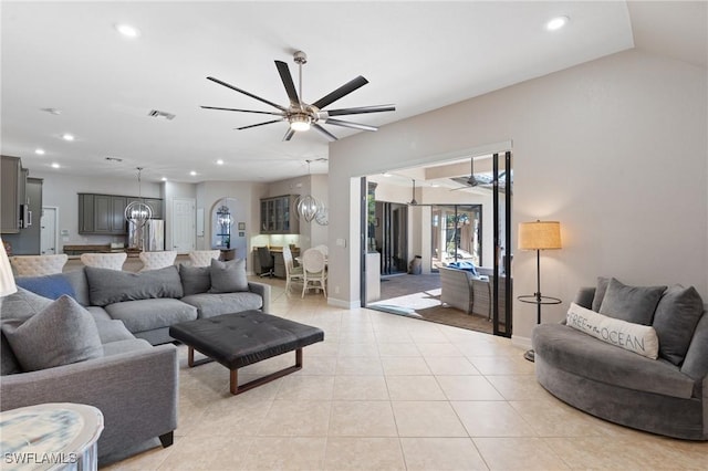 tiled living room featuring ceiling fan and vaulted ceiling