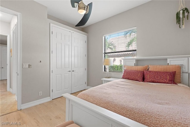 bedroom with ceiling fan, light wood-type flooring, and a closet