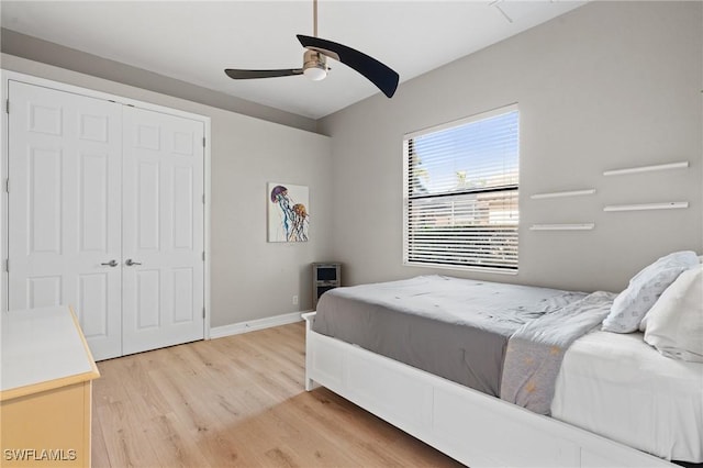 bedroom with ceiling fan, light hardwood / wood-style flooring, and a closet