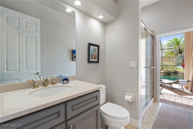 bathroom featuring walk in shower, vanity, tile patterned floors, and toilet