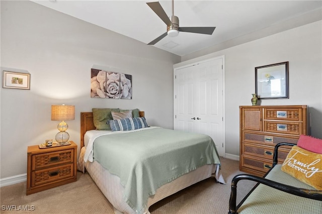 bedroom featuring light carpet, a closet, and ceiling fan