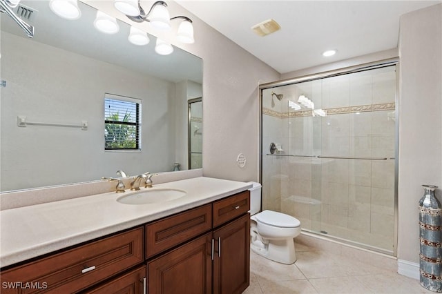 bathroom featuring toilet, tile patterned flooring, a shower with door, and vanity