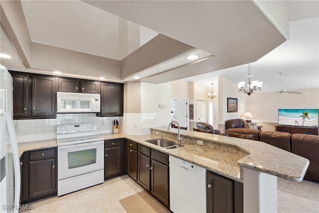 kitchen with white appliances, ceiling fan with notable chandelier, sink, light tile patterned floors, and kitchen peninsula