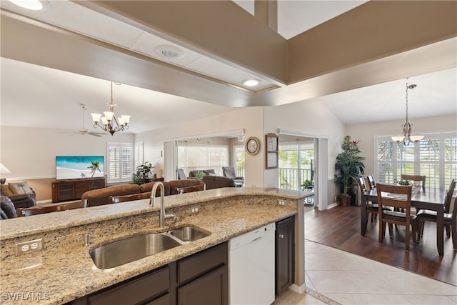 kitchen featuring light stone countertops, dishwasher, hanging light fixtures, and ceiling fan with notable chandelier