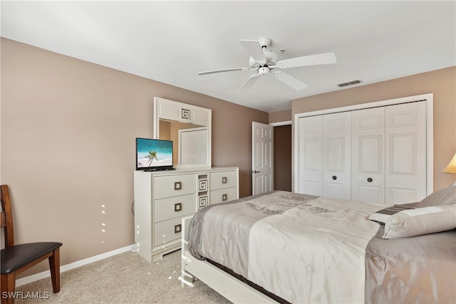 bedroom featuring ceiling fan, a closet, and light carpet