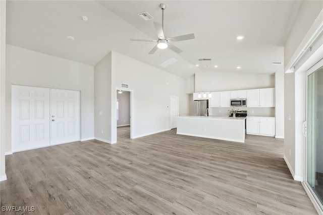 unfurnished living room featuring light hardwood / wood-style floors, high vaulted ceiling, and ceiling fan