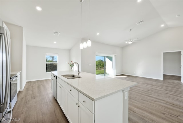 kitchen featuring sink, hanging light fixtures, a kitchen island with sink, white cabinets, and appliances with stainless steel finishes