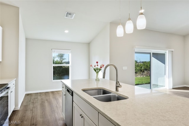 kitchen with appliances with stainless steel finishes, white cabinetry, hanging light fixtures, and sink