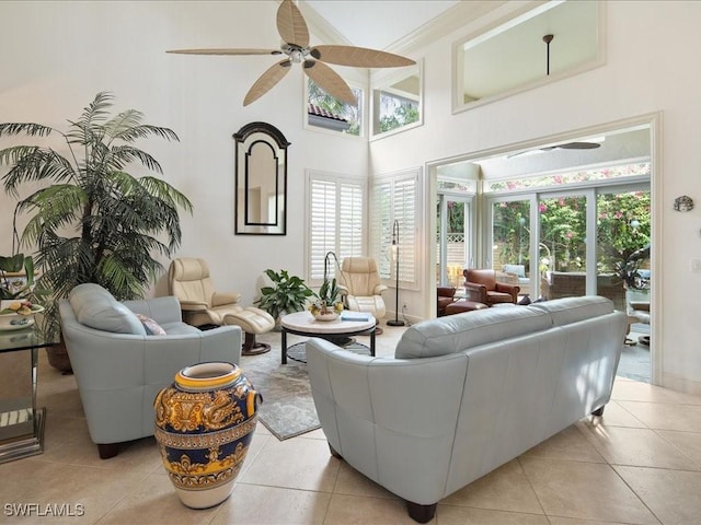 living room featuring ceiling fan, light tile patterned flooring, and a high ceiling