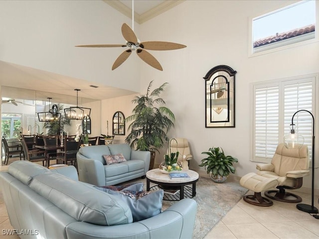 living room with ceiling fan with notable chandelier, light tile patterned floors, ornamental molding, and a wealth of natural light