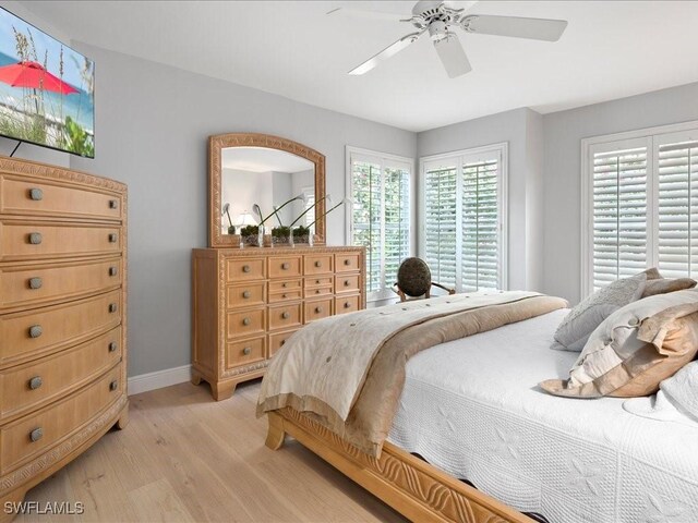 bedroom with ceiling fan, light hardwood / wood-style floors, and multiple windows