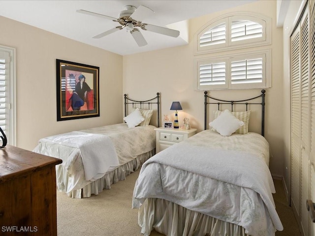 bedroom with ceiling fan, a closet, and light colored carpet