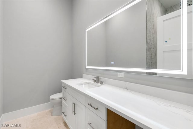 bathroom featuring toilet, vanity, and tile patterned flooring