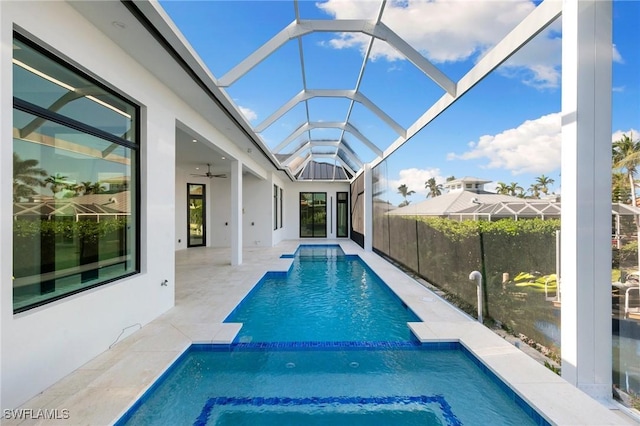 view of swimming pool featuring a ceiling fan, a pool with connected hot tub, a lanai, and a patio