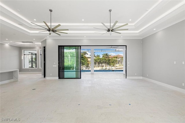 spare room with ceiling fan, a tray ceiling, and crown molding