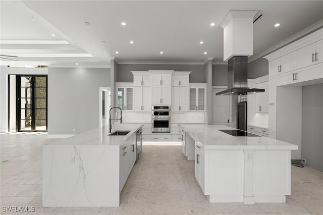 kitchen featuring light stone countertops, black electric stovetop, white cabinetry, and a large island