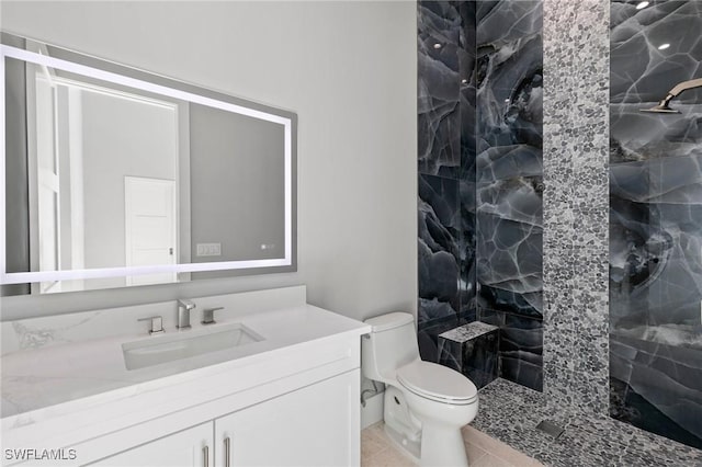 bathroom with tile patterned floors, toilet, a stall shower, and vanity