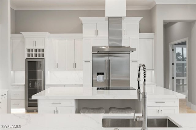 kitchen featuring wine cooler, white cabinetry, stainless steel built in fridge, and light stone countertops